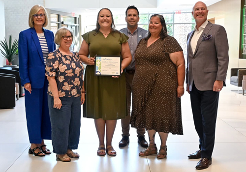 Four staff members from Southeast Community College accepted the Lincoln Family Friendly Workplace certification from Lincoln Partnership for Economic Development and Lincoln Littles. The woman in the center holds the certificate.
