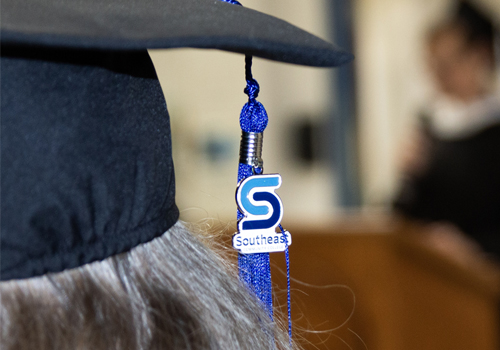 An SCC tassel is hanging off a black mortar board at SCC's prison education graduation ceremony. 