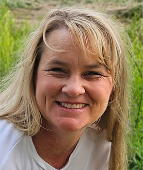Ginger Buchanan smiling in a field. 