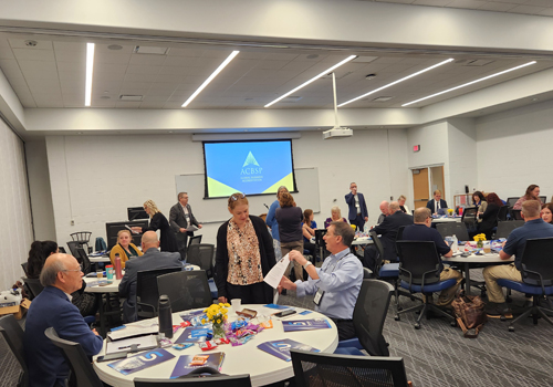 Business faculty networking at round tables in a conference room at the ACBSP Region 5 Conference at SCC. 